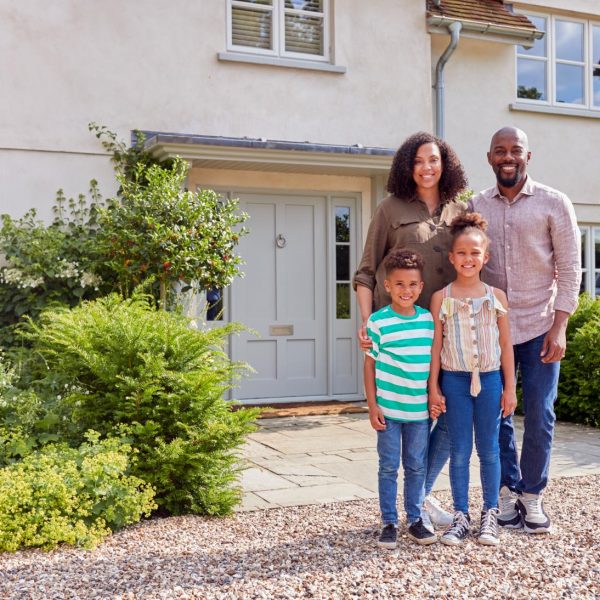 portrait-of-smiling-family-standing-outside-home-t-2023-11-27-04-57-11-utc (1)